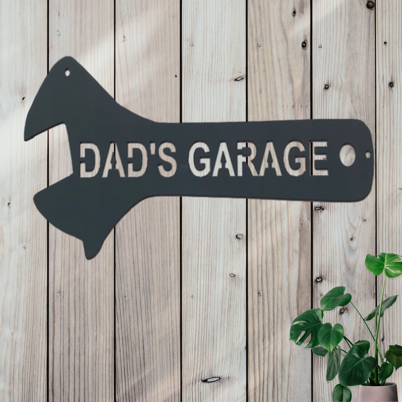 Sign shaped like a wrench that says Dad's Garage on the handle. 