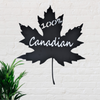 Black metal sign in the shape of a maple leaf with the words 100% Canadian cut out of it.