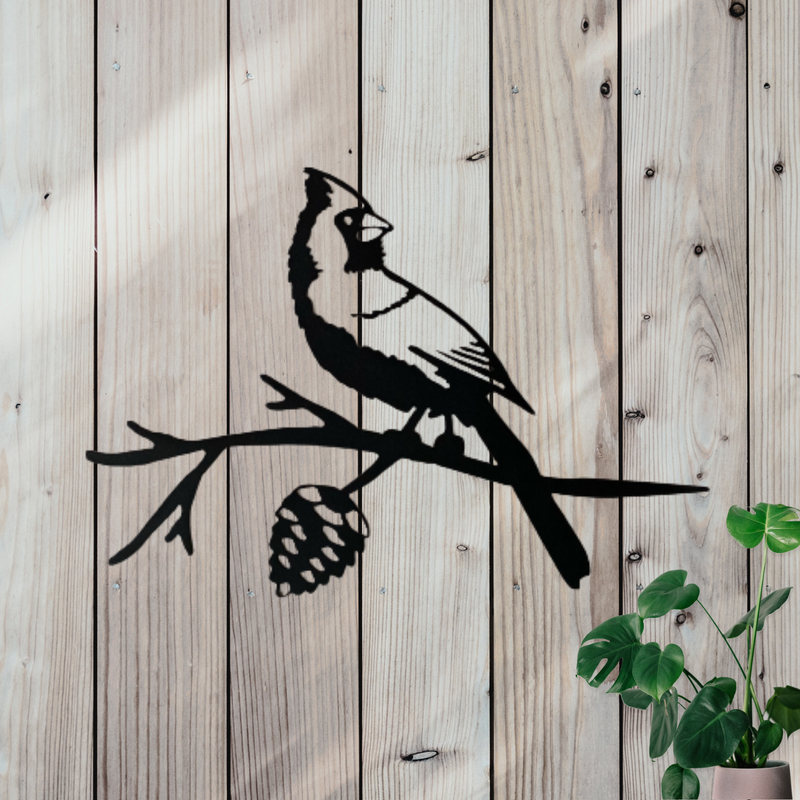 Metal decor featuring a cardinal standing on a branch. 