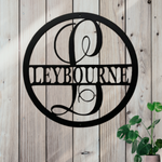 Decorative metal sign with 'LEYBOURNE' on a wooden background