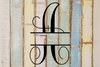 Decorative split letter monogram 'A' on a rustic wooden background with pastel colors.