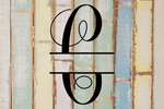 Decorative split letter monogram "C" on a wooden background with a rustic feel