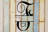 Decorative split letter monogram 'F' on a wooden background with a rustic feel.