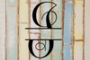 Decorative split letter monogram 'I' on a rustic wooden background with pastel colors.