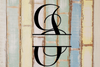 Decorative split letter monogram "J" on a textured wooden background with pastel colors.