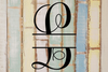 Split letter monogram 'L' on a wooden background with a rustic finish.