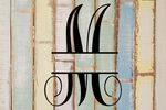Decorative split letter monogram 'M' on a textured wooden background with pastel colors.