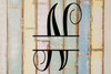 Decorative split letter monogram 'N' on a textured wooden background with pastel colors.
