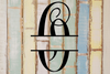 Decorative split letter monogram "O" on a textured wooden background