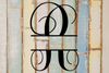 Decorative split letter monogram "R" on a textured wooden background