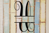 Decorative split letter monogram 'U' on a rustic wooden background with pastel colors.