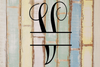 Decorative split letter monogram "V" on a rustic wooden background with pastel colours.