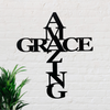 Black metal sign with the words Amazing Grace in shape of a cross.  The word amazing is vertical and the word grace is horizontal.
