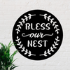 Circular metal sign with decorative design around edges and the words bless our nest in the middle. 