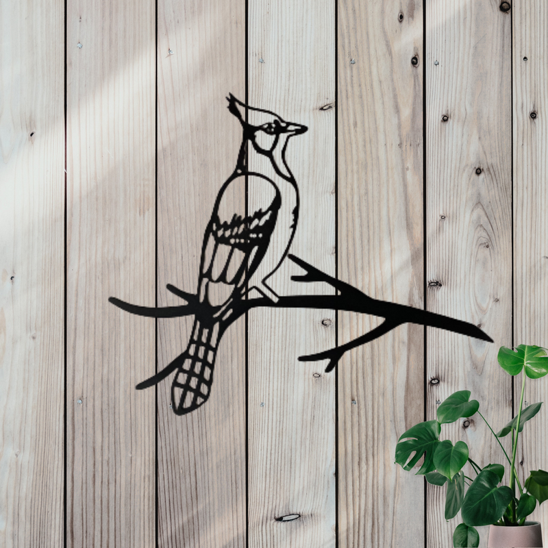 Black metal wall art of a blue jay bird perched on a branch.