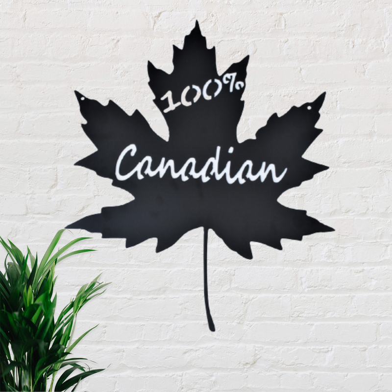 Black metal sign in the shape of a maple leaf with the words 100% Canadian cut out of it.