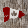 Metal Canadian flag with the look of torn edges and the maple leaf cut out of the middle. 